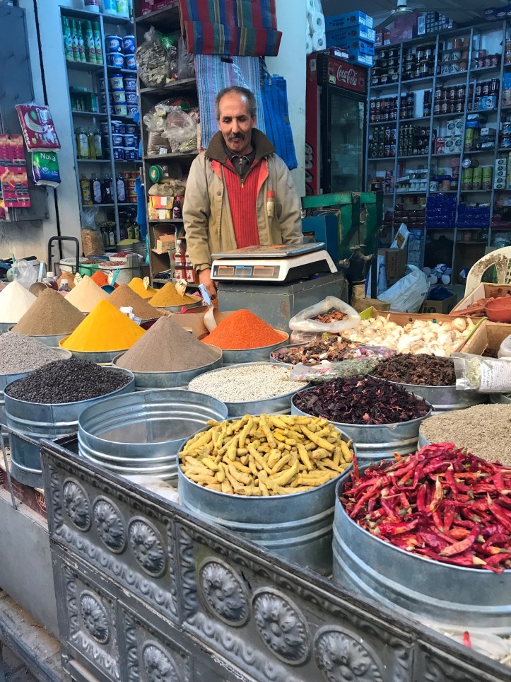 Venditore di spezie colorate in un souk in Marocco
