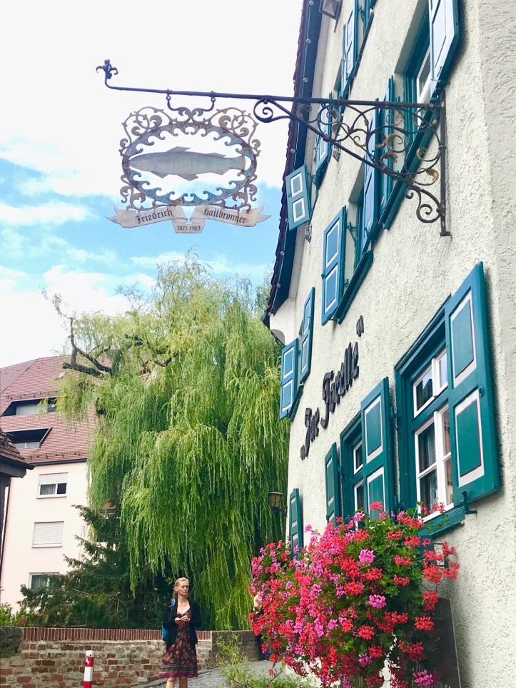 Finestra fiorita e insegna antica a Ulm, Germania