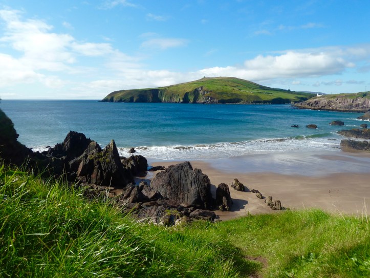 Spiaggia irlandese dall’acqua turchese e circondata da verdi scogliere