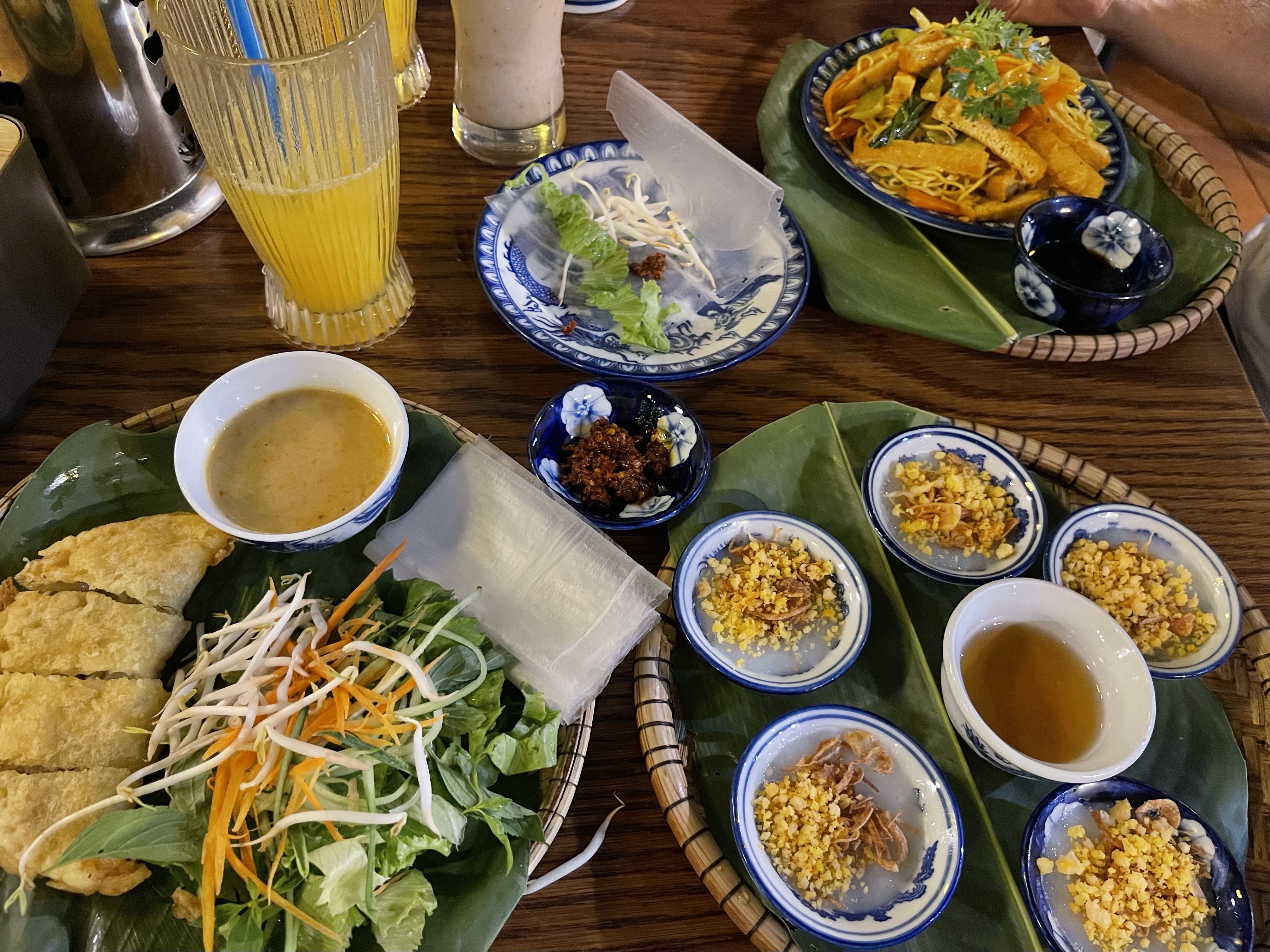 Tavola imbandita con piatti tipici del Vietnam centrale, crêpes  salate del Vietnam 