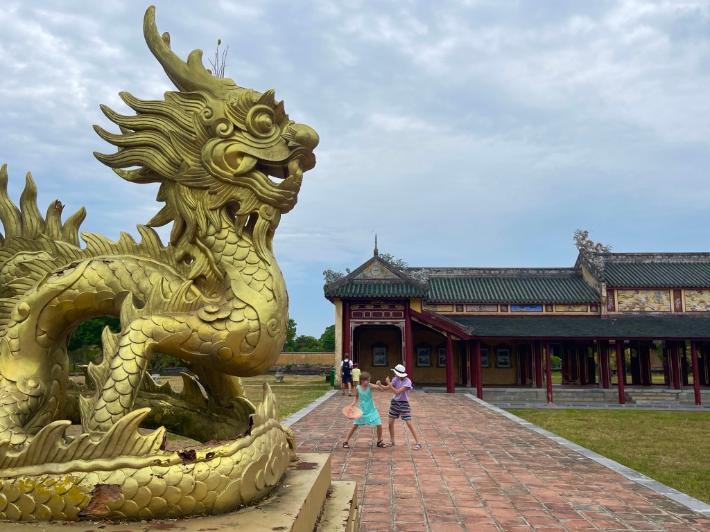 Bambini che giocano davanti a un dragone d’oro, nella città proibita di Hue 