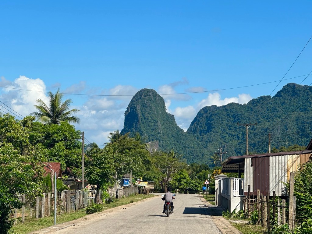 Strada di campagna nei dintorni di Vang Vieng, Laos, con le tipiche montagne carsiche sullo sfondo